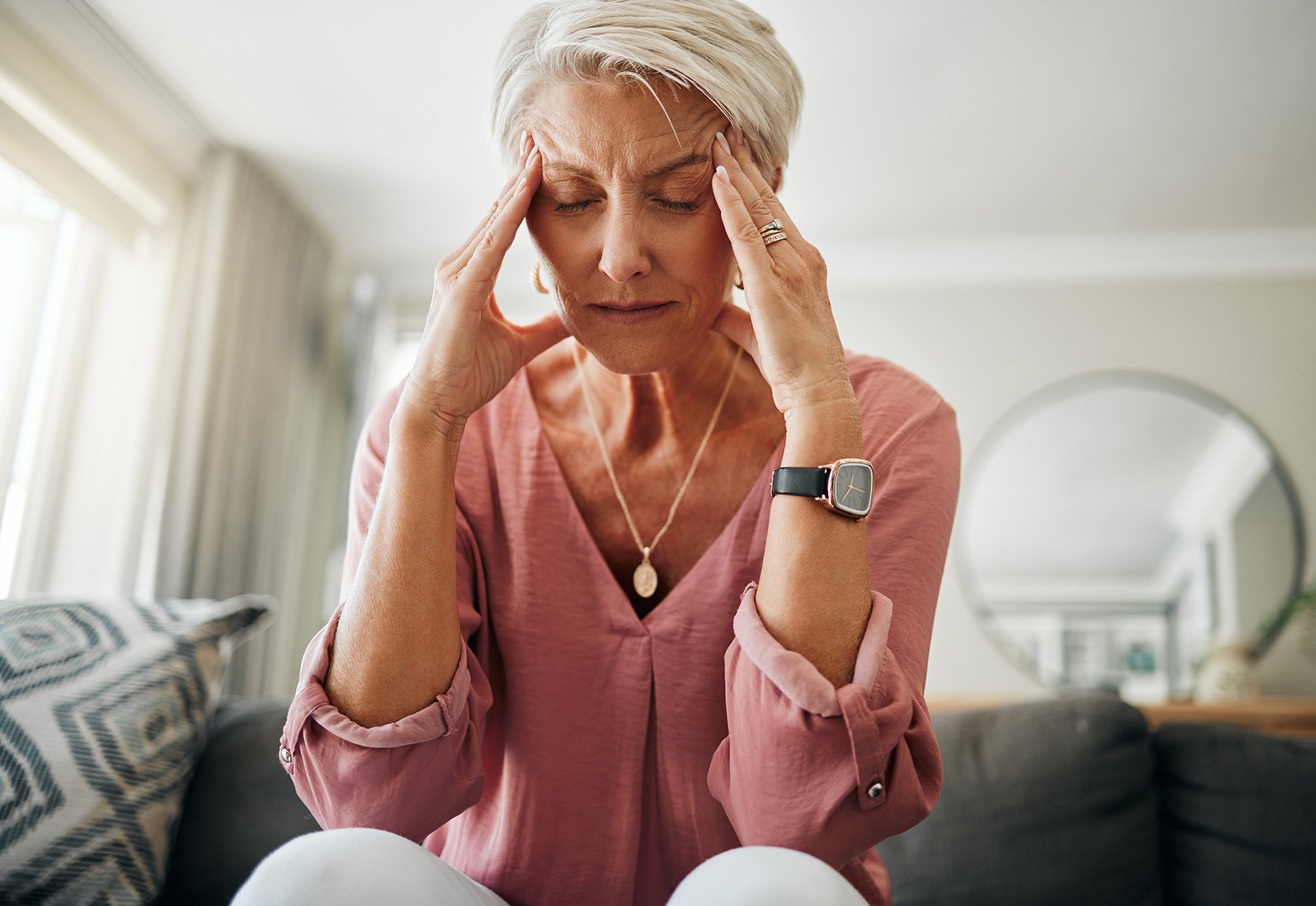 A senior woman experiencing headache & needing Hormone replacement therapy.