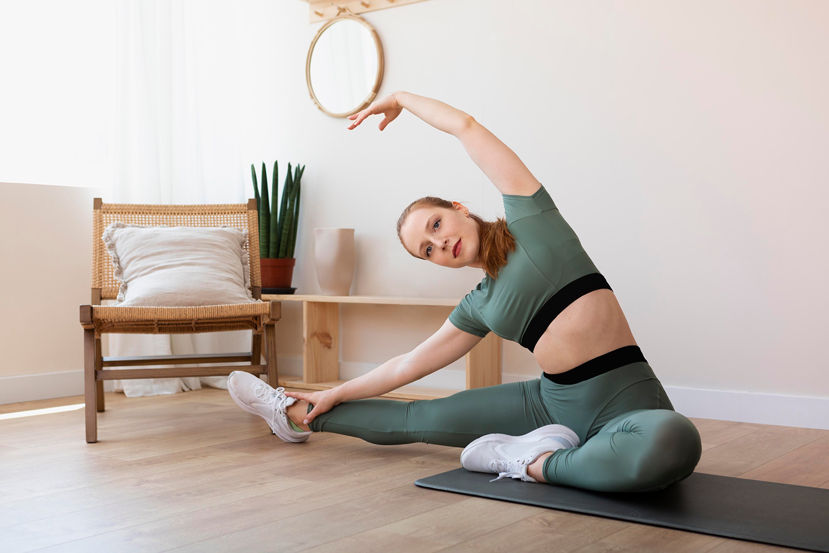 A woman stretching on a mat after chiropractic care.