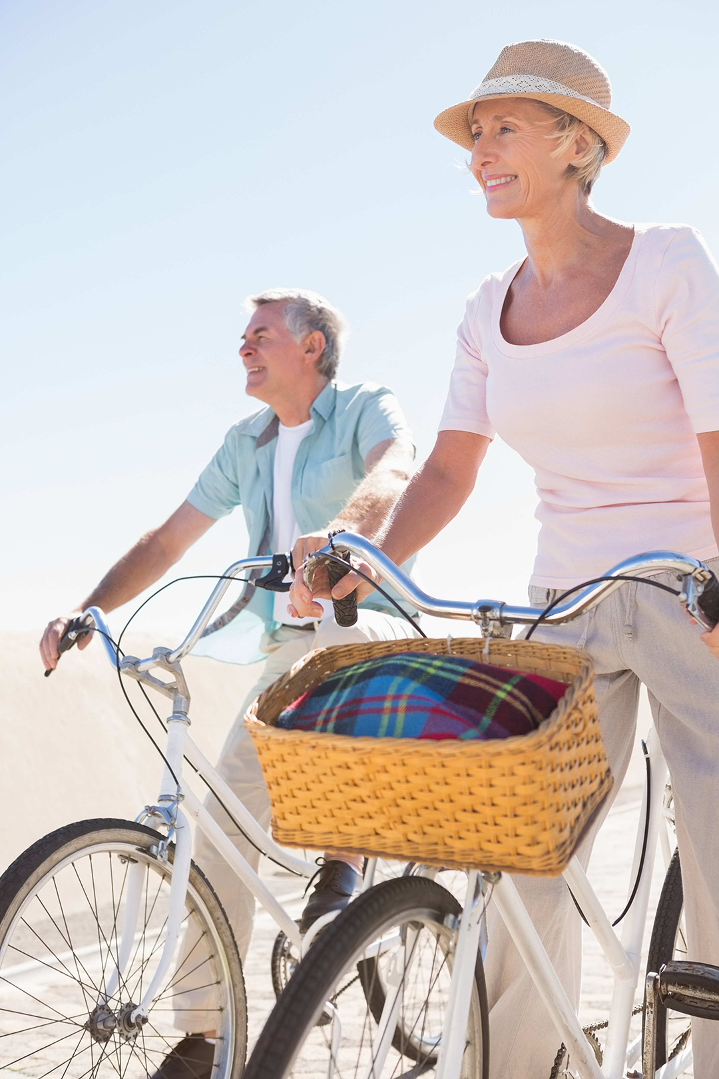 Elderly couple enjoying a bike ride thanks to peptide therapy.