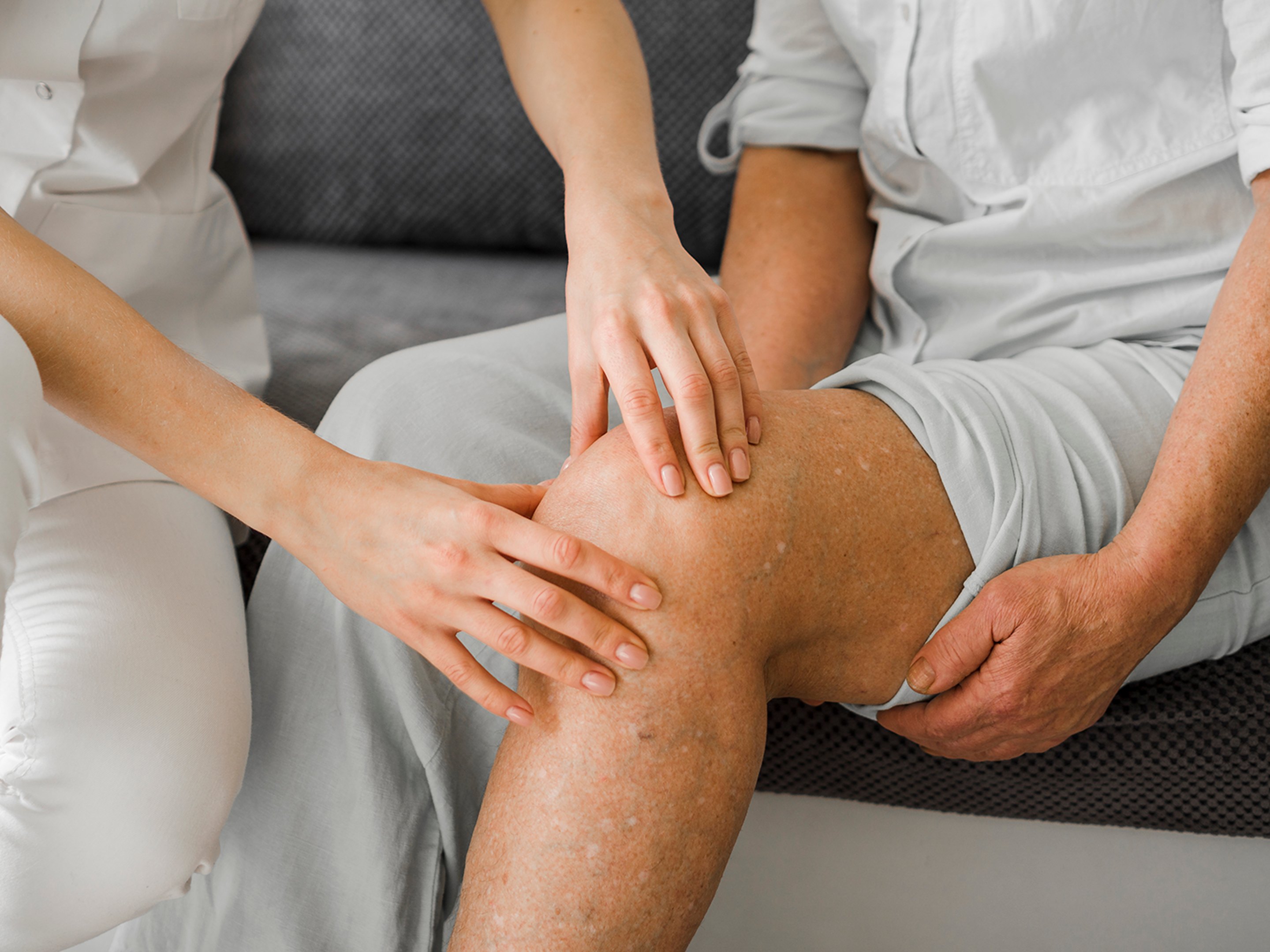 A doctor examining a patient's knee to determine the need of stem cell therapy.
